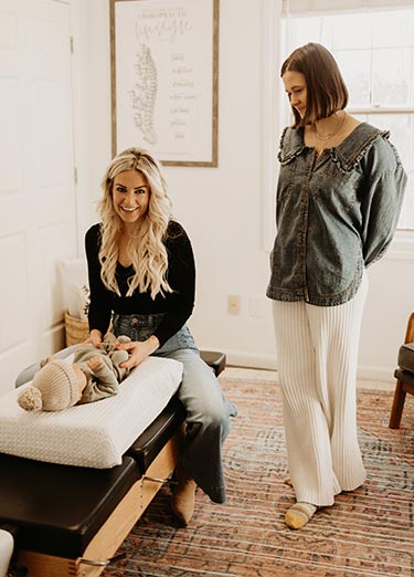 adjusting-baby-well-family-chiro Dr Lauren adjusting a baby at Well Family Chiropractic in Mequon, WI