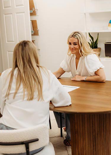 consult-well-family-chiro A woman meets with Dr Lauren for her chiropractic first appointment at Well Family Chiro