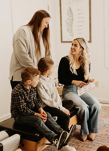 family-reviews-eval-well-family-chiro a family reviews their scans and evaluation at their follow-up appointment at Well Family Chiropractic